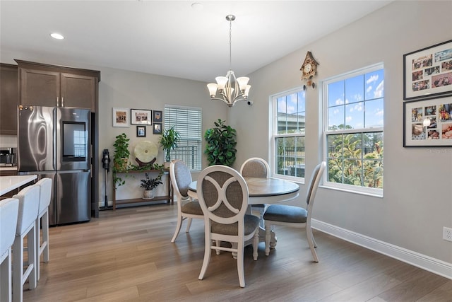 dining room featuring light hardwood / wood-style floors and a chandelier