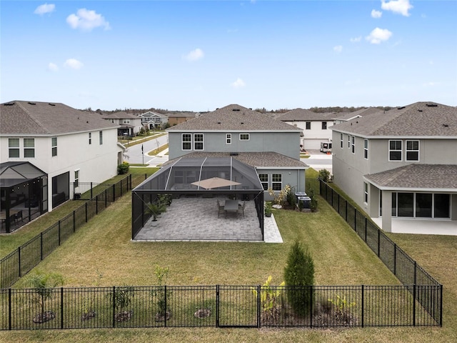 rear view of property featuring glass enclosure, a patio area, and a lawn