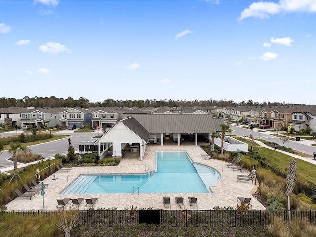 rear view of property with a community pool and a patio