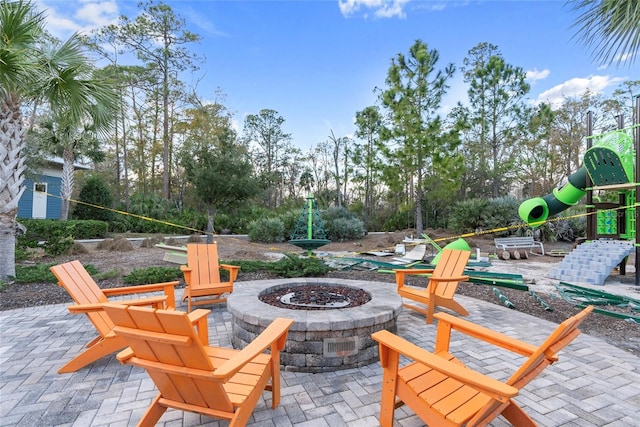 view of patio with a playground and an outdoor fire pit