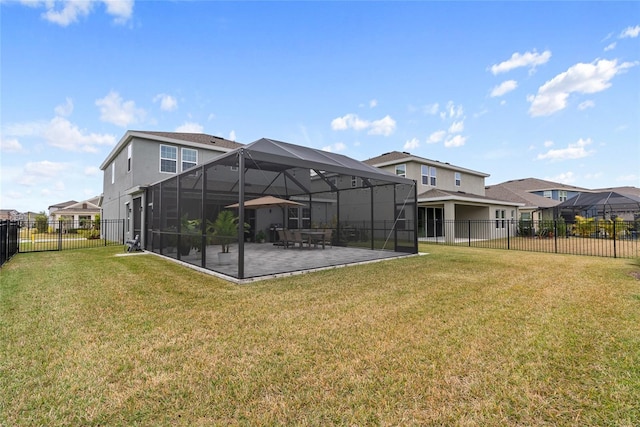 rear view of property featuring a lawn, a patio area, and glass enclosure