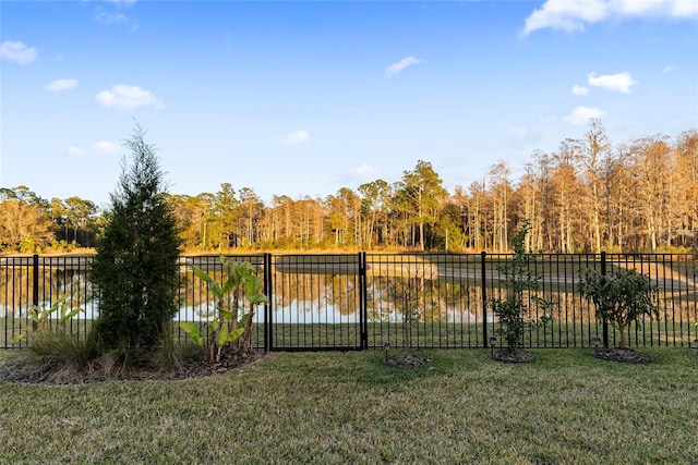 view of gate featuring a lawn and a water view