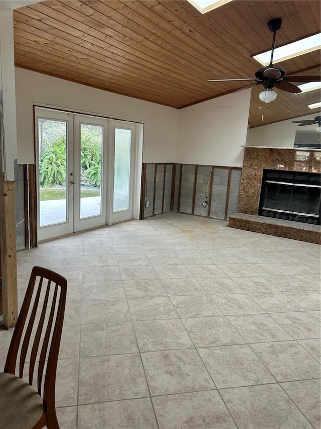 unfurnished living room with a premium fireplace, wooden ceiling, french doors, and ceiling fan