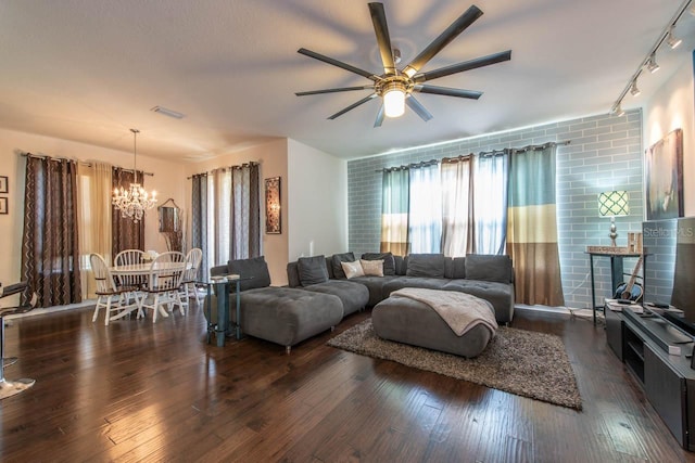 living room with dark hardwood / wood-style flooring, ceiling fan with notable chandelier, and track lighting