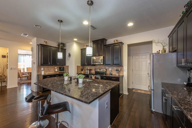 kitchen featuring a kitchen island, hanging light fixtures, dark hardwood / wood-style floors, and appliances with stainless steel finishes