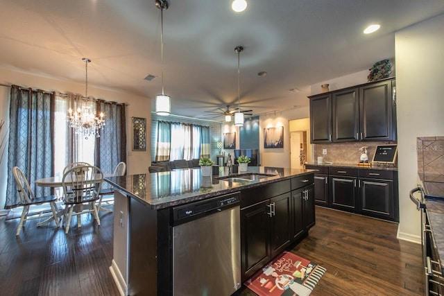 kitchen featuring dark wood-type flooring, sink, dishwasher, hanging light fixtures, and an island with sink