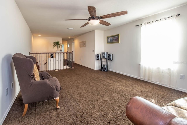 sitting room featuring dark colored carpet and ceiling fan