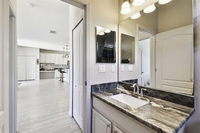 bathroom featuring tasteful backsplash, vanity, and hardwood / wood-style flooring