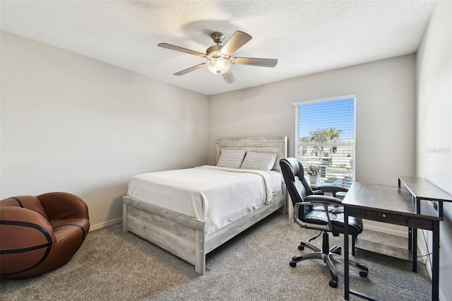 carpeted bedroom featuring ceiling fan and a textured ceiling