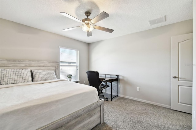 bedroom featuring ceiling fan, carpet floors, and a textured ceiling