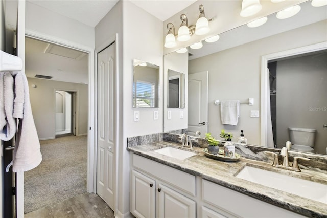 bathroom with hardwood / wood-style floors, vanity, and toilet