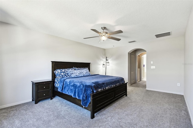 carpeted bedroom featuring a textured ceiling and ceiling fan