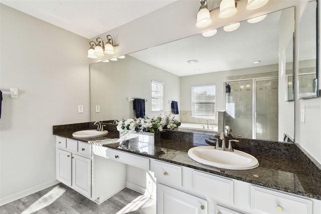 bathroom featuring hardwood / wood-style flooring, vanity, and walk in shower