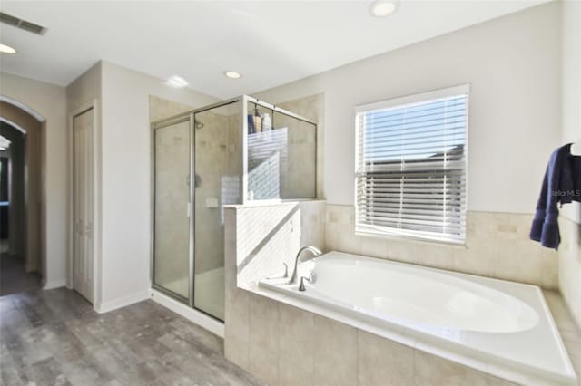 bathroom featuring separate shower and tub