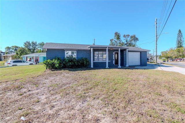 single story home with a sunroom, a garage, and a front lawn