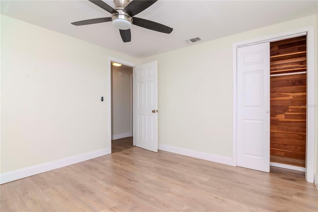 unfurnished bedroom featuring ceiling fan, a closet, and light hardwood / wood-style flooring