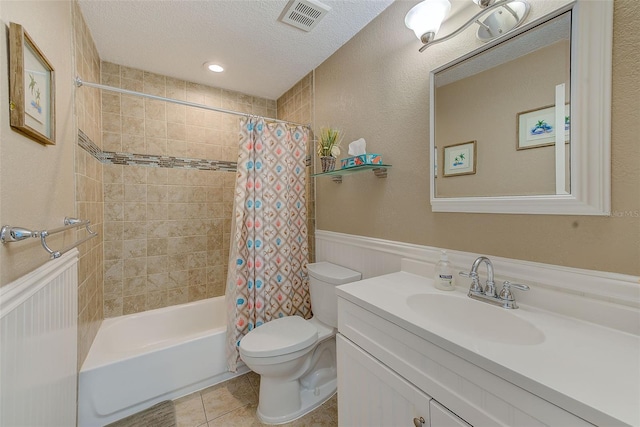 full bathroom featuring shower / bath combination with curtain, tile patterned floors, vanity, a textured ceiling, and toilet