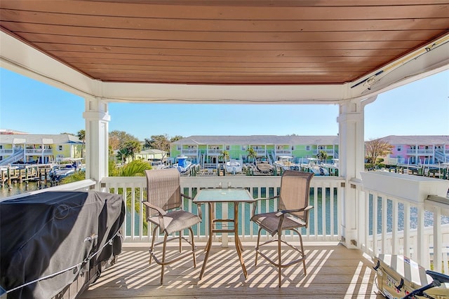 wooden deck featuring a water view and area for grilling