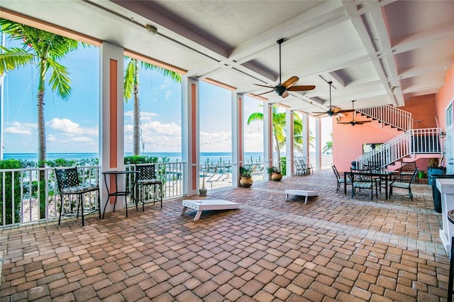 view of patio / terrace with ceiling fan and a water view