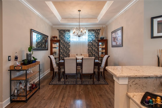 dining area featuring ornamental molding, dark hardwood / wood-style floors, a notable chandelier, and a tray ceiling