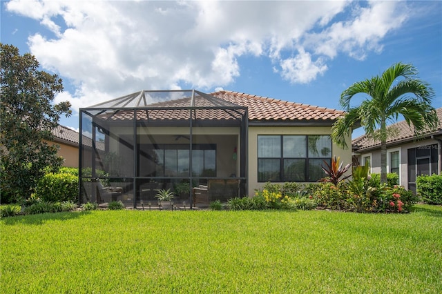 back of property featuring a yard and glass enclosure