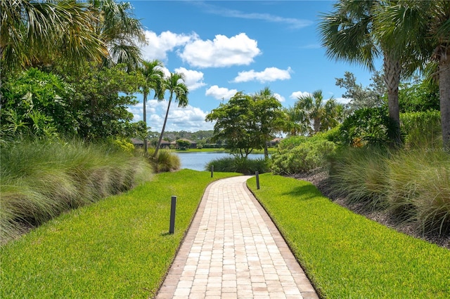 surrounding community with a lawn and a water view