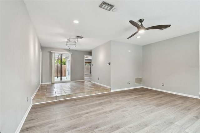 empty room with ceiling fan and light hardwood / wood-style flooring