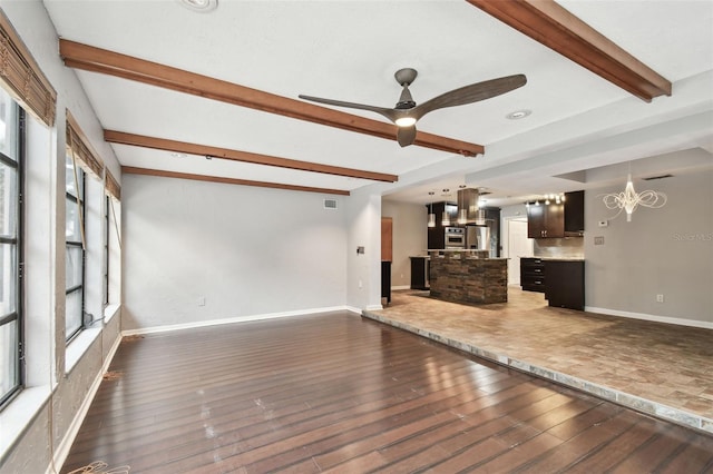 unfurnished living room with beam ceiling, dark hardwood / wood-style flooring, and ceiling fan with notable chandelier