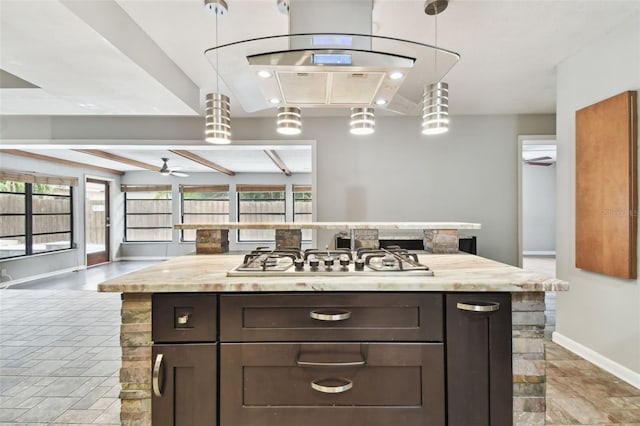 kitchen with dark brown cabinetry, ceiling fan, a center island, hanging light fixtures, and stainless steel gas stovetop