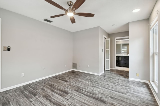 unfurnished bedroom featuring hardwood / wood-style flooring, ceiling fan, and multiple windows