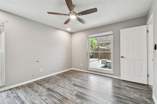 unfurnished room with dark hardwood / wood-style floors and ceiling fan