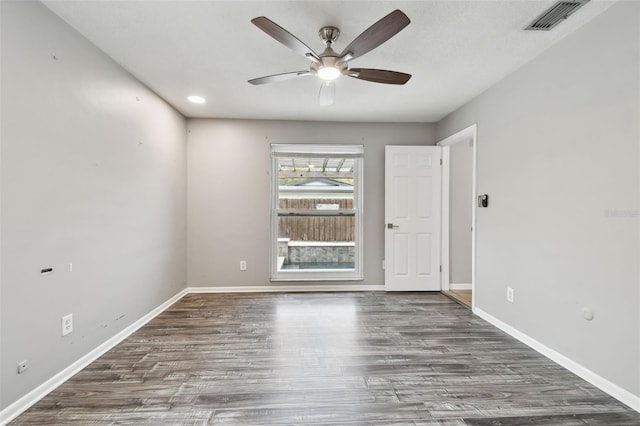 spare room with ceiling fan and dark hardwood / wood-style flooring