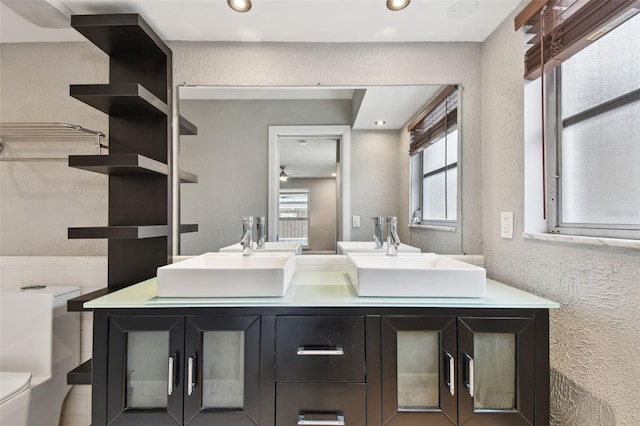 bathroom featuring vanity, toilet, and ceiling fan