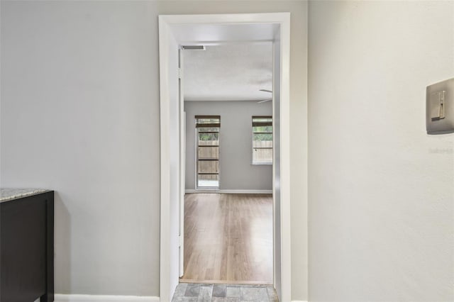 hall featuring a textured ceiling and light hardwood / wood-style floors