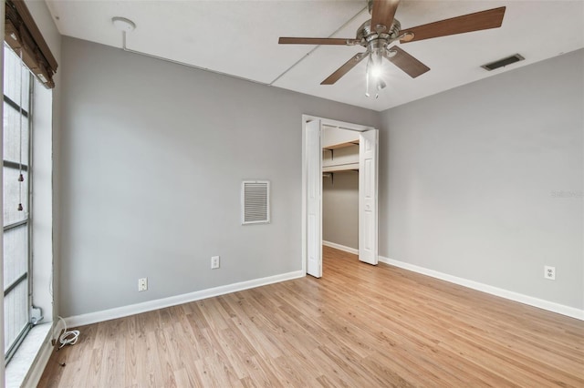 unfurnished bedroom featuring ceiling fan, a closet, and light hardwood / wood-style flooring