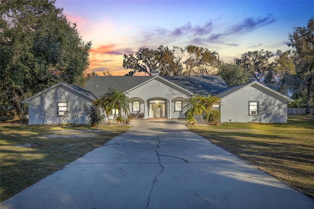 single story home featuring a lawn