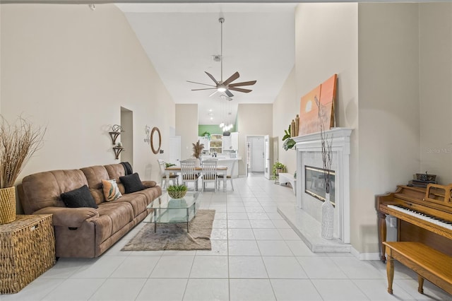 tiled living room with a high end fireplace, high vaulted ceiling, and ceiling fan