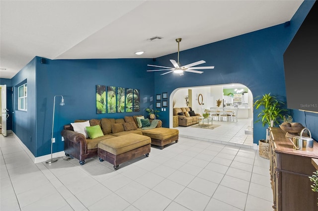 living room featuring lofted ceiling, light tile patterned flooring, and ceiling fan