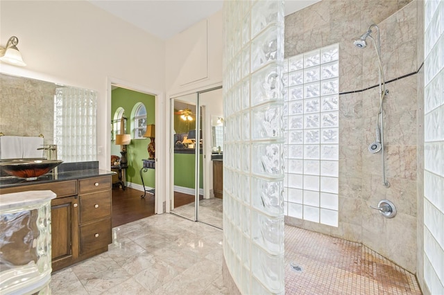 bathroom featuring tiled shower and vanity