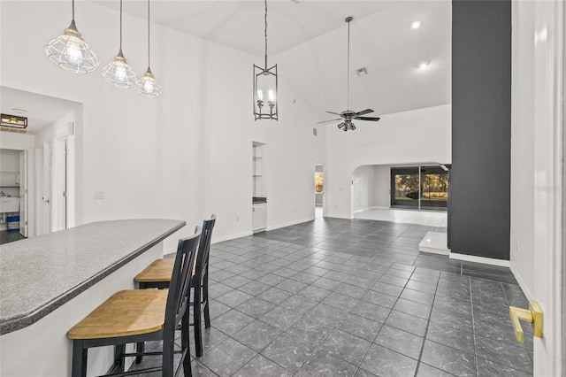 dining area with ceiling fan and high vaulted ceiling