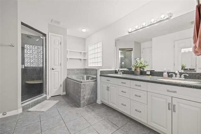 bathroom featuring independent shower and bath, tile patterned flooring, a textured ceiling, and vanity