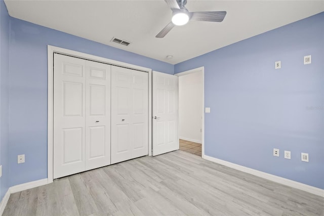 unfurnished bedroom featuring ceiling fan, light hardwood / wood-style floors, and a closet