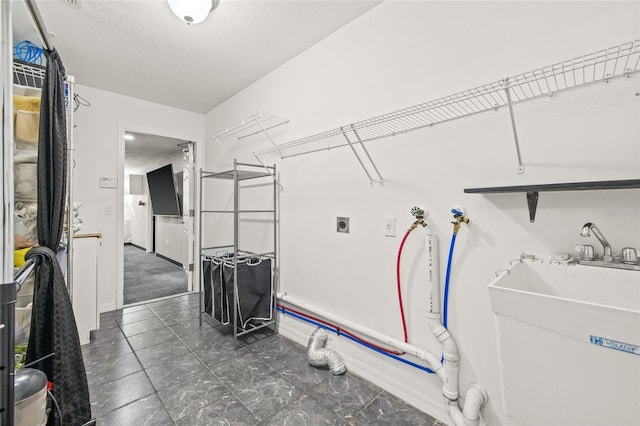 laundry room with sink, a textured ceiling, hookup for an electric dryer, and washer hookup