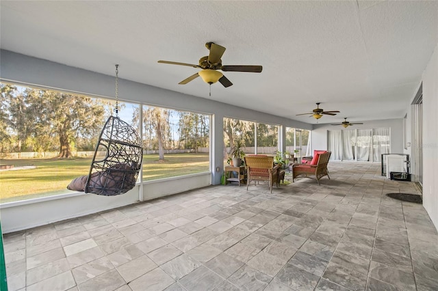 unfurnished sunroom featuring ceiling fan