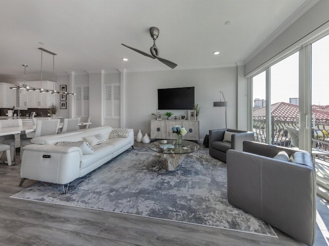 living room with ceiling fan, wood-type flooring, and crown molding