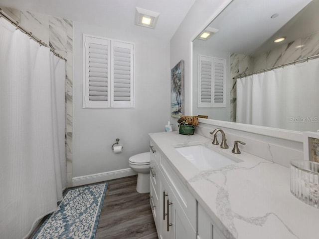 bathroom featuring walk in shower, vanity, wood-type flooring, and toilet