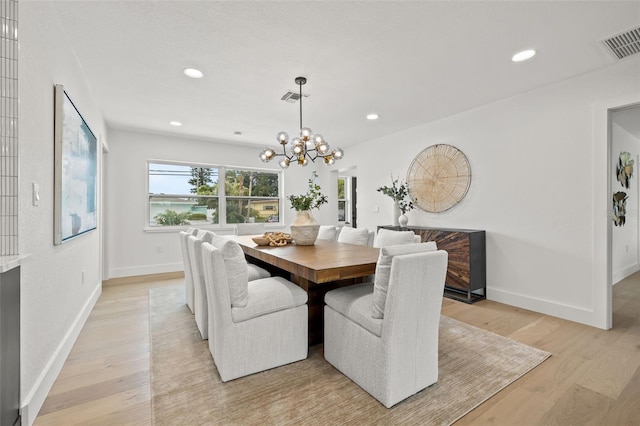 dining area with a chandelier and light hardwood / wood-style flooring