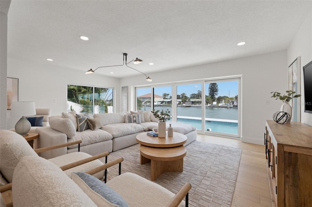 living room featuring a textured ceiling and light wood-type flooring