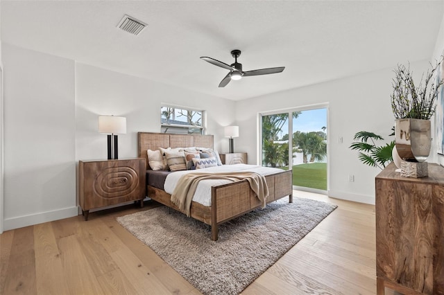 bedroom with multiple windows, access to outside, and light wood-type flooring