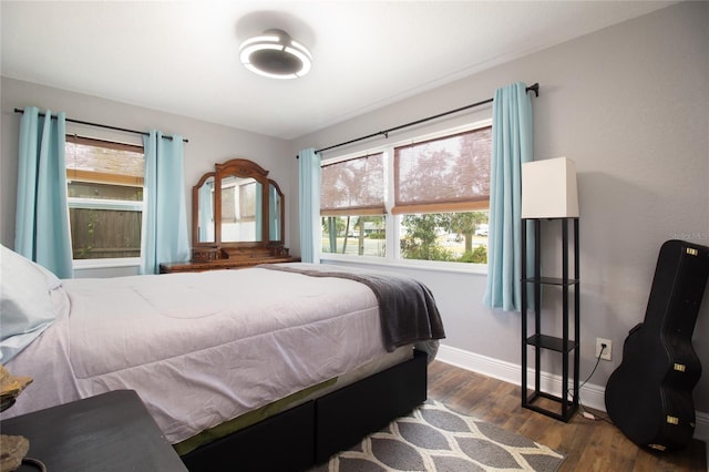 bedroom featuring dark hardwood / wood-style flooring and multiple windows